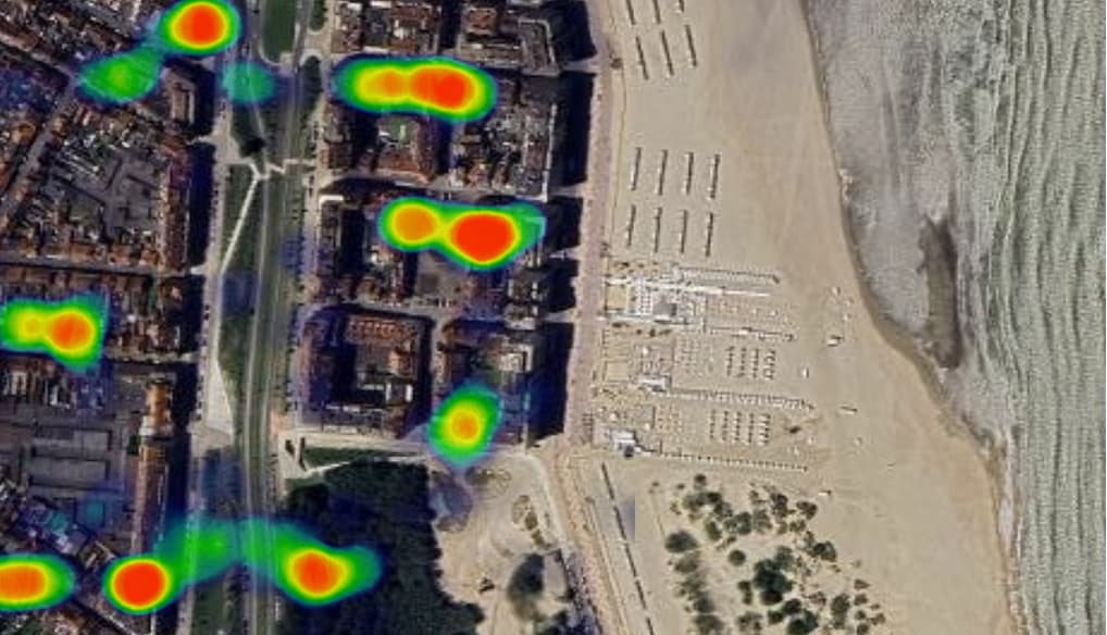 A heatmap of visitor density over a coastal town, the busiest spots glowing red